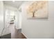 Inviting hallway with light walls, wood floors, and a decorative painting at 985 Penstemon Dr, Henderson, CO 80640