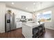 Bright kitchen features stainless steel appliances, white cabinetry, granite countertops, and a breakfast bar at 985 Penstemon Dr, Henderson, CO 80640