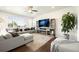 Open-concept living room with large sectional, TV, and a cozy fireplace at 985 Penstemon Dr, Henderson, CO 80640