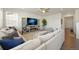 Spacious living room with stylish sectional sofa and large entertainment center at 985 Penstemon Dr, Henderson, CO 80640