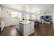 Open concept living space featuring a kitchen island, dining area, and comfortable living room at 985 Penstemon Dr, Henderson, CO 80640