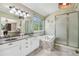 Bright bathroom featuring double sinks, a soaking tub, and a glass-enclosed shower at 7513 Simms Ct, Arvada, CO 80005