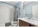 Modern bathroom with stylish vanity, white tile shower, and blue walls at 7513 Simms Ct, Arvada, CO 80005