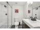Beautiful bathroom showcasing a white vanity, a shower with glass doors and a grey tile floor at 7513 Simms Ct, Arvada, CO 80005