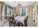 Bright dining room featuring a chandelier, large windows with curtains, and a dining table with chairs at 7513 Simms Ct, Arvada, CO 80005