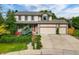Charming two-story home with a well-manicured lawn, mature trees, and a three-car garage at 7513 Simms Ct, Arvada, CO 80005