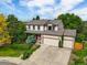 Beautiful home with a large three-car garage, lush landscaping, mature trees, and a welcoming front entrance at 7513 Simms Ct, Arvada, CO 80005