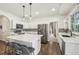 Bright kitchen features a large center island with marble countertops, stainless steel appliances, and pendant lighting at 7513 Simms Ct, Arvada, CO 80005