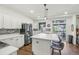 Bright kitchen features a large center island with marble countertops, stainless steel appliances, and access to the back deck at 7513 Simms Ct, Arvada, CO 80005