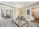 Cozy living room view leading into a dining area, featuring a glass coffee table and neutral decor at 7513 Simms Ct, Arvada, CO 80005