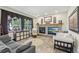 Cozy living room featuring a brick fireplace, neutral paint colors, and large windows with lots of natural light at 7513 Simms Ct, Arvada, CO 80005