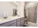 Bathroom with double sinks, gray cabinets, walk-in shower and decor at 14700 E 104Th Ave # 1404, Commerce City, CO 80022
