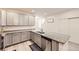 Bright kitchen featuring gray cabinets, granite countertops, and stainless steel appliances, seamlessly connecting to the staircase at 14700 E 104Th Ave # 1404, Commerce City, CO 80022