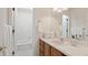 Well-lit bathroom with a white countertop, wooden cabinets, and a shower-tub combo at 15543 Quivas St, Broomfield, CO 80023