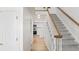 Bright hallway with hardwood floors leading to the modern kitchen with white cabinetry and stainless steel appliances at 15543 Quivas St, Broomfield, CO 80023