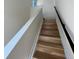 A staircase with light wood steps and a sleek black handrail at 1284 Osceola St, Denver, CO 80204