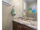 Elegant powder room featuring granite countertop, modern fixtures, and eye-catching wall art at 7967 E 139Th Pl, Thornton, CO 80602