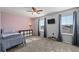 Well-lit bedroom featuring a twin bed, storage unit, and large windows at 7967 E 139Th Pl, Thornton, CO 80602