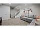 Living room showcasing a staircase, a sectional sofa, and modern decor at 7967 E 139Th Pl, Thornton, CO 80602