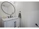 Stylish powder room featuring a modern sink, a black faucet, and a round mirror at 7967 E 139Th Pl, Thornton, CO 80602