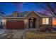 House exterior at dusk with stone accents and a two-car garage at 6321 Spring Gulch St, Frederick, CO 80516