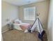 Bright bedroom with a comfortable bed, playful teepee, and a side table, creating a welcoming space at 6321 Spring Gulch St, Frederick, CO 80516