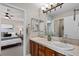 Bathroom with dual sinks, tile countertop, and a view into the primary bedroom at 5322 Devils Head Cir, Golden, CO 80403