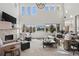 Open-concept living room featuring a stone fireplace, tall windows, and comfortable seating arrangements at 5322 Devils Head Cir, Golden, CO 80403