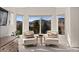Cozy sitting area with mountain views, comfortable seating, and natural light from the bay windows at 5322 Devils Head Cir, Golden, CO 80403