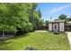 Backyard featuring lush green grass, mature trees, and a storage shed at 380 E 111Th Pl, Northglenn, CO 80233