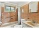 A bathroom features a tub and shower, a window, and a vanity with a marble top at 380 E 111Th Pl, Northglenn, CO 80233