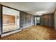 Inviting living room features unique wood paneling, carpet flooring, and entry to another room at 380 E 111Th Pl, Northglenn, CO 80233