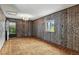 The spacious living room has unique wood paneled walls, carpet, and a decorative chandelier at 380 E 111Th Pl, Northglenn, CO 80233