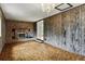 A warm living area features a brick fireplace, wood paneling, and stylish lighting at 380 E 111Th Pl, Northglenn, CO 80233