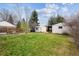 Lush backyard featuring green lawn, detached garages, and perimeter fencing at 1220 Magnolia St, Denver, CO 80220