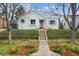 Charming, renovated home with fresh white paint, stone walkway, and mature landscaping at 1220 Magnolia St, Denver, CO 80220