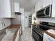 Well-lit kitchen with stainless steel appliances, white cabinets, and unique tiled floors at 1220 Magnolia St, Denver, CO 80220