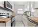 Stylish kitchen with white cabinets, butcher block countertops, and modern appliances at 1220 Magnolia St, Denver, CO 80220
