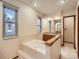 Bright bathroom featuring a soaking tub, natural light, and wood-trimmed vanity at 6141 W Evans Pl, Lakewood, CO 80227