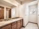 Bathroom featuring a double sink vanity with drawers and a large mirror above at 6141 W Evans Pl, Lakewood, CO 80227