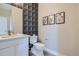 Elegant powder room featuring decorative wallpaper and modern fixtures at 6864 Bryant Ct, Denver, CO 80221