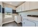 Efficient laundry room with modern washer and dryer, ample counter space, and plenty of storage cabinets at 6864 Bryant Ct, Denver, CO 80221