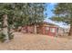 Brick home with a spacious backyard, mature trees, and outdoor seating area at 2095 Newland St, Edgewater, CO 80214