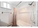 Bright bathroom featuring tiled walls, bathtub with shower, and a window providing natural light at 2095 Newland St, Edgewater, CO 80214