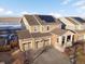 A high aerial view showcasing a two-story house with a three-car garage, solar panels, and an inviting porch at 3140 S Nepal Way, Aurora, CO 80013