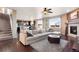 Bright, open-concept living room with a fireplace, hardwood floors, a large sectional, and modern kitchen in background at 3140 S Nepal Way, Aurora, CO 80013