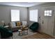 Cozy living room featuring a gray sofa and emerald green armchairs at 1690 S Umatilla St, Denver, CO 80223