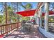 Outdoor deck features a dining table under a red umbrella, BBQ grill, and views of the treeline at 24860 N Mountain Park Dr, Evergreen, CO 80439