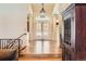 Grand foyer featuring hardwood floors, an elegant chandelier, and decorative glass doors that lead to the main living space at 24860 N Mountain Park Dr, Evergreen, CO 80439