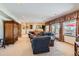 Spacious living room featuring plush seating, large windows, and access to an outdoor deck at 24860 N Mountain Park Dr, Evergreen, CO 80439